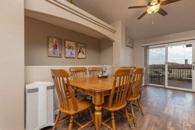 dining area with dark wood-style floors, visible vents, radiator heating unit, a ceiling fan, and vaulted ceiling