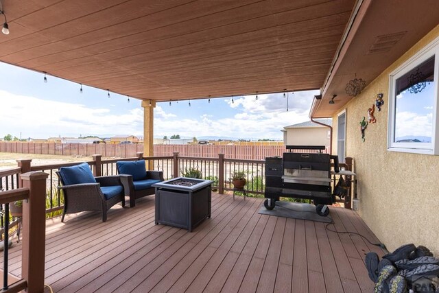 wooden deck featuring an outdoor living space with a fire pit, fence, and visible vents