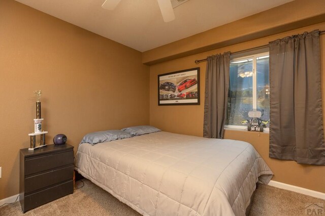 carpeted bedroom featuring a ceiling fan and baseboards