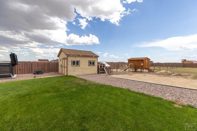 view of yard featuring a storage shed, an outdoor structure, and a fenced backyard