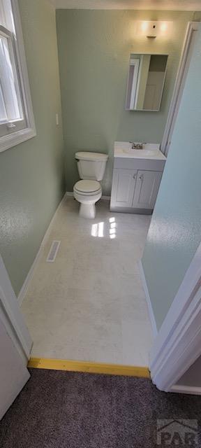 605 E 8th St, La Junta, CO 81050 - bathroom featuring vanity, toilet, and baseboards