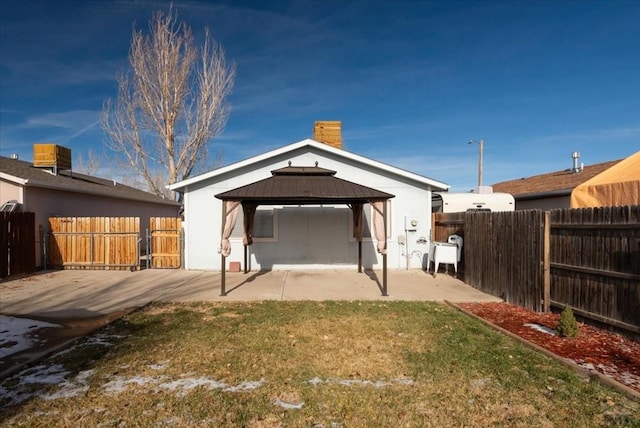 back of house featuring a patio area, a fenced backyard, metal roof, and a gazebo