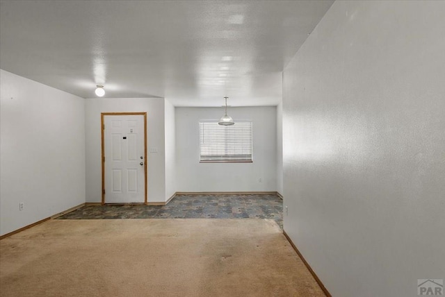 carpeted foyer entrance featuring baseboards