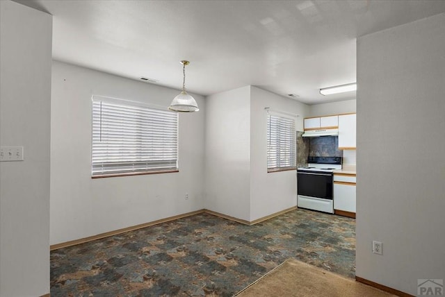 kitchen featuring pendant lighting, visible vents, electric range, under cabinet range hood, and baseboards