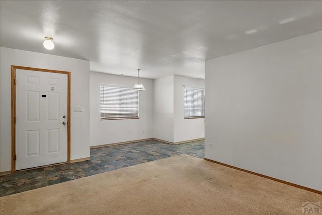 carpeted foyer with baseboards