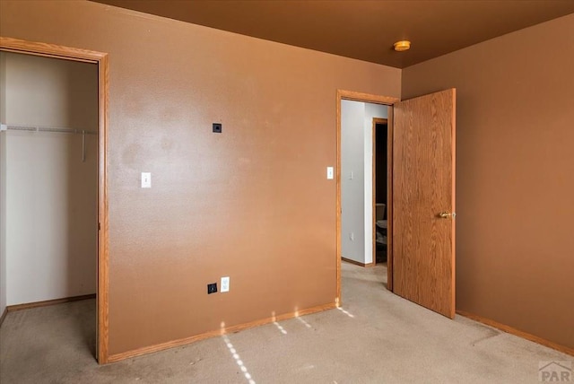 unfurnished bedroom with baseboards, a closet, and light colored carpet