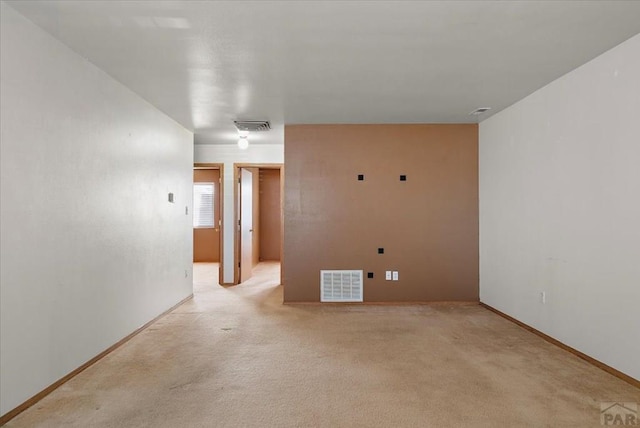 unfurnished room featuring light carpet, baseboards, and visible vents