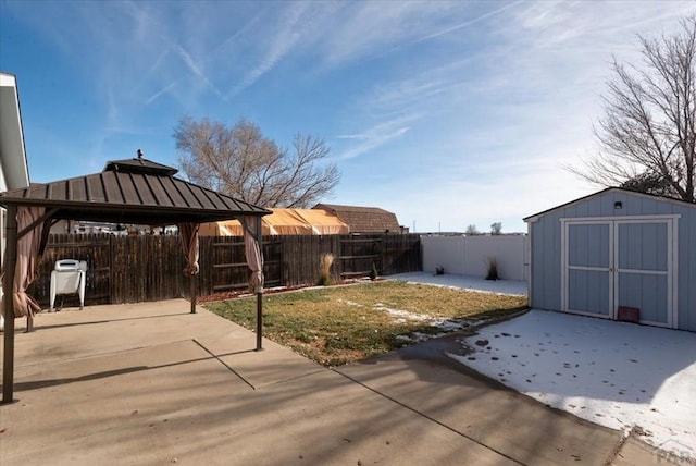 view of yard with an outbuilding, a gazebo, a patio area, a shed, and a fenced backyard