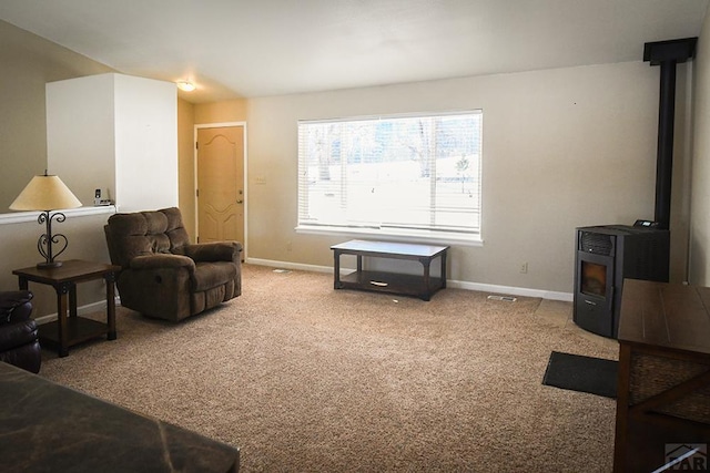 living room with carpet, a wood stove, and baseboards