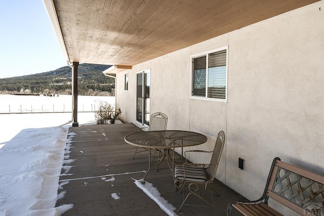 snow covered patio featuring fence