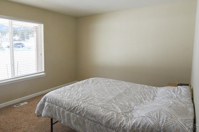 carpeted bedroom featuring visible vents and baseboards