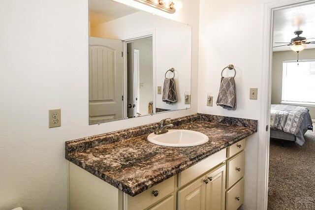 bathroom featuring ceiling fan, connected bathroom, and vanity