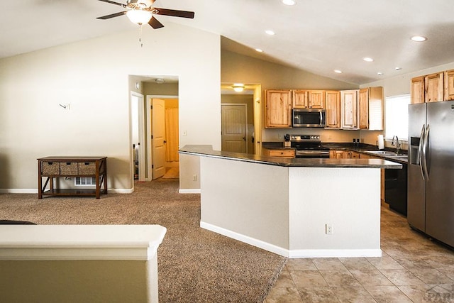 kitchen featuring vaulted ceiling, stainless steel appliances, dark countertops, and a sink