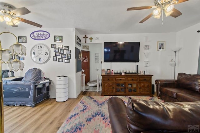 living area with light wood-style floors and ceiling fan