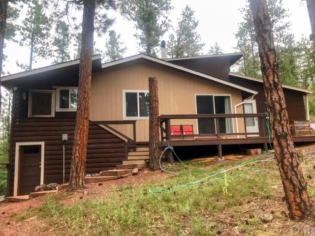 back of property with a garage and a wooden deck