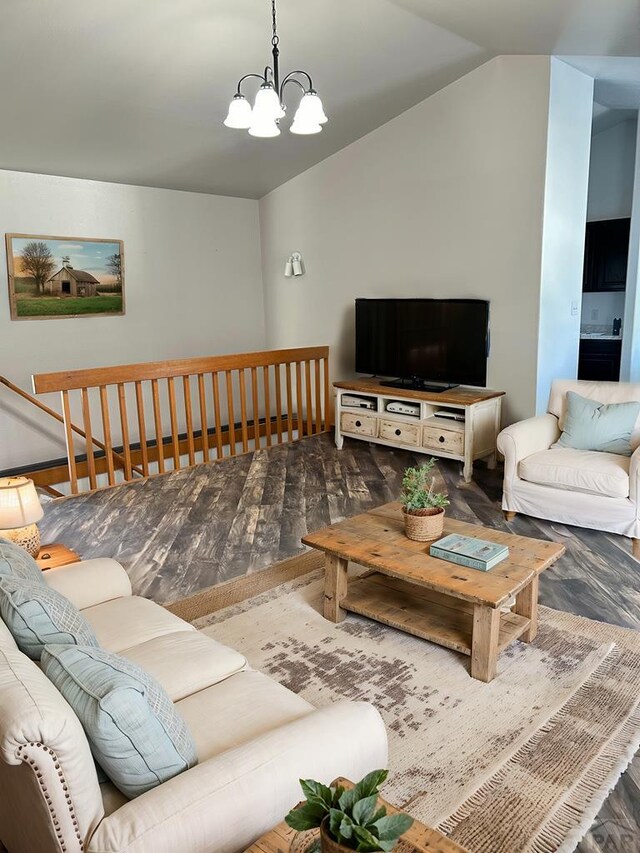 living area with lofted ceiling, an inviting chandelier, and wood finished floors