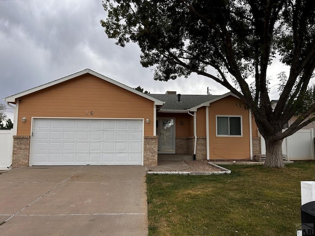 single story home featuring a garage, driveway, a front yard, and brick siding