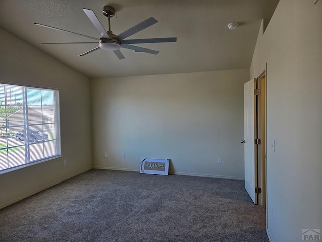 carpeted spare room featuring lofted ceiling, ceiling fan, and baseboards