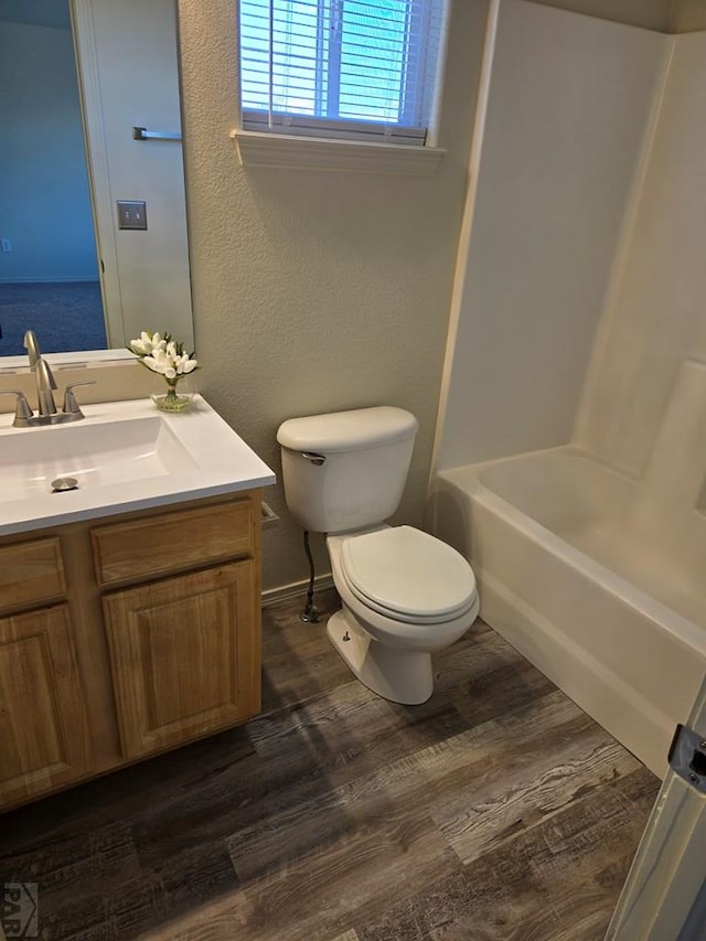 bathroom with bathing tub / shower combination, vanity, toilet, and wood finished floors