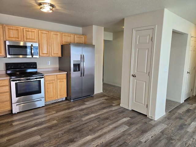 kitchen featuring appliances with stainless steel finishes, dark wood finished floors, light countertops, and light brown cabinetry