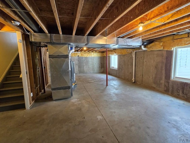 basement featuring heating unit and stairway