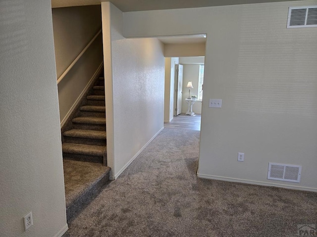 corridor with baseboards, visible vents, carpet flooring, and stairs