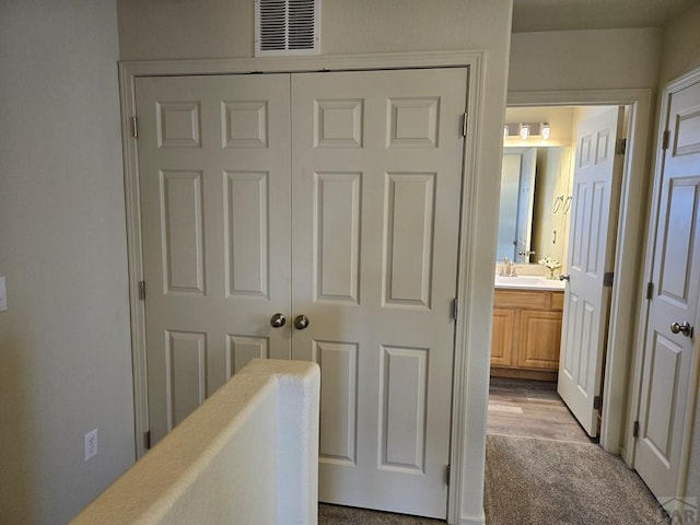 hallway with visible vents and a sink