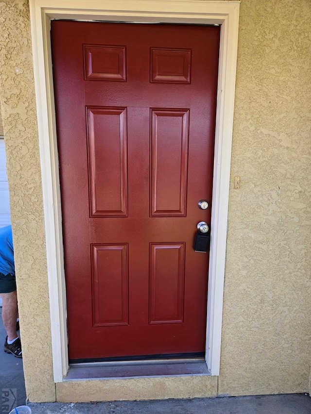 property entrance with stucco siding