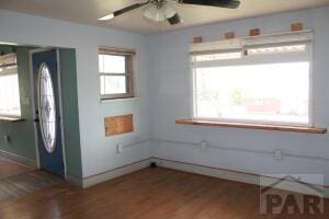 entryway with dark wood-style floors, ceiling fan, and baseboards