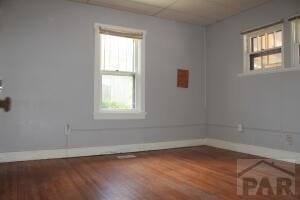 empty room with baseboards and wood finished floors