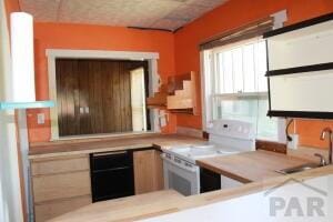 kitchen with a sink, dishwasher, light countertops, and white range with electric cooktop