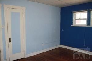 spare room with dark wood-style floors and baseboards