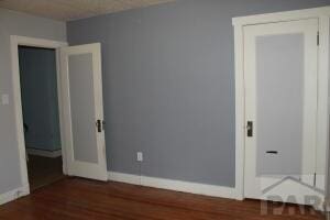 unfurnished bedroom with dark wood finished floors and baseboards