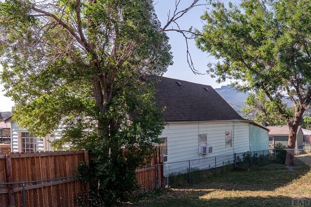 318 E Goddard Ave, Trinidad, CO 81082 - view of property exterior with roof with shingles, a fenced backyard, and cooling unit