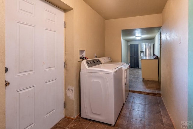318 E Goddard Ave, Trinidad, CO 81082 - laundry room featuring washer and clothes dryer, baseboards, and dark tile patterned flooring