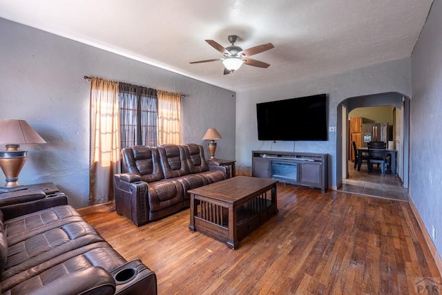 318 E Goddard Ave, Trinidad, CO 81082 - living room featuring arched walkways, a ceiling fan, hardwood / wood-style floors, and baseboards