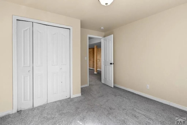 unfurnished bedroom featuring baseboards, a closet, and light colored carpet