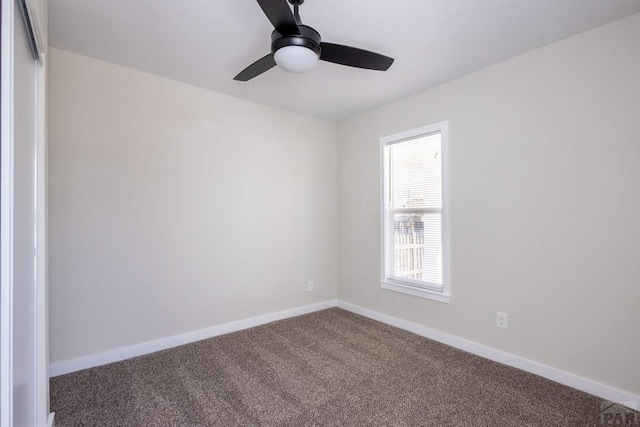 carpeted spare room with baseboards and a ceiling fan