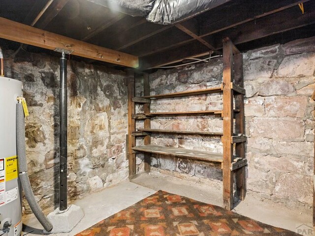 unfinished basement featuring water heater