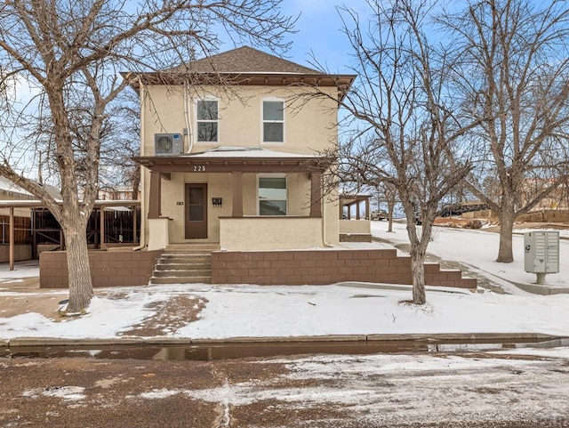 view of front of house featuring covered porch, roof with shingles, and stucco siding