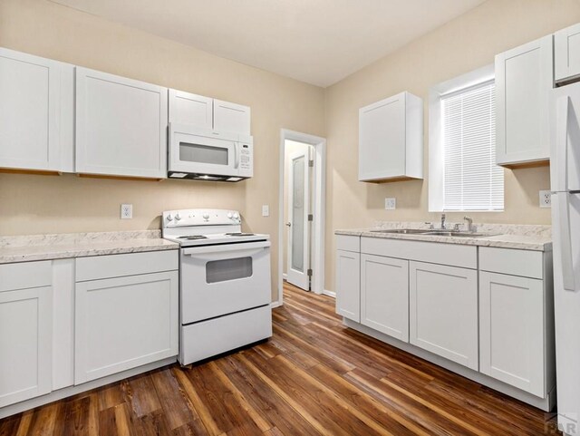 kitchen with white appliances, dark wood-style floors, white cabinetry, and a sink