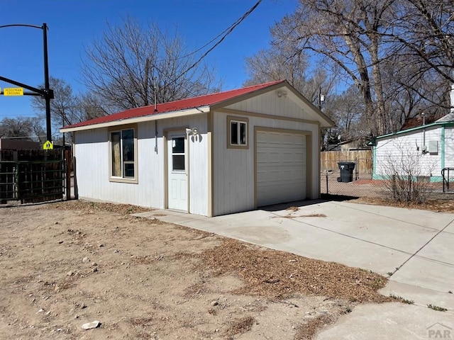 detached garage with driveway and fence