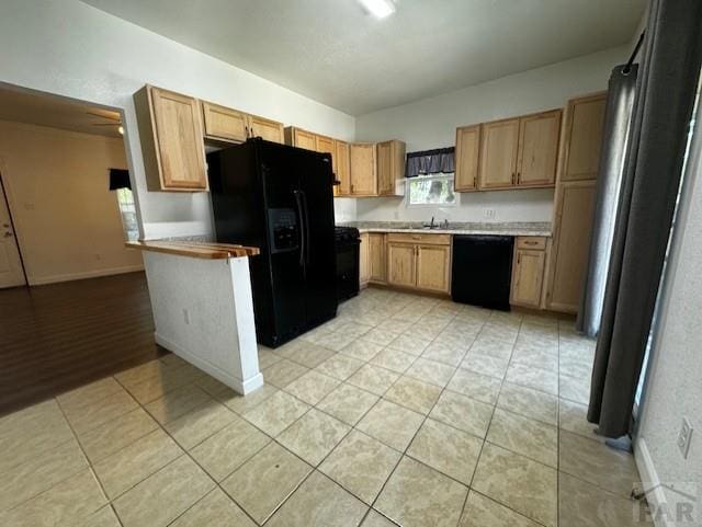 kitchen featuring black appliances, light tile patterned flooring, light countertops, and baseboards