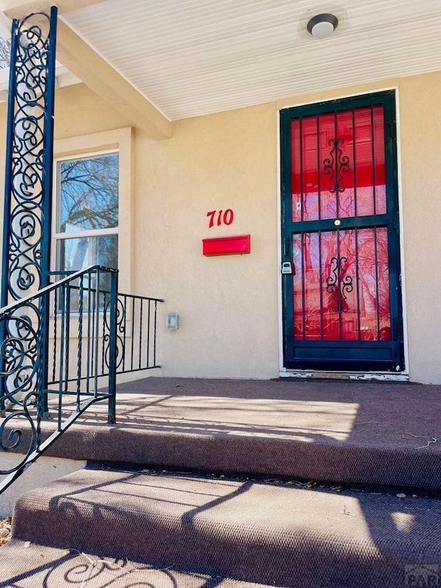 view of exterior entry with stucco siding