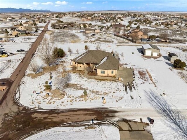 snowy aerial view featuring a residential view and a mountain view