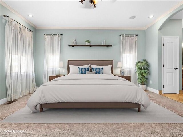 bedroom with baseboards, ornamental molding, and light colored carpet