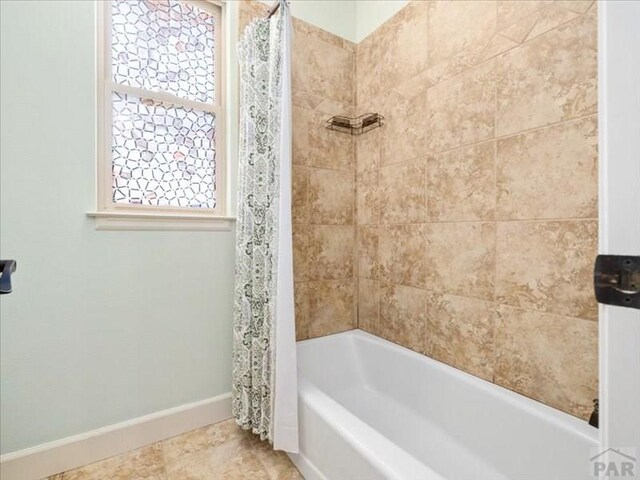 full bath with shower / bathtub combination with curtain and baseboards