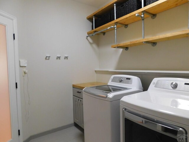 laundry area featuring separate washer and dryer and cabinet space