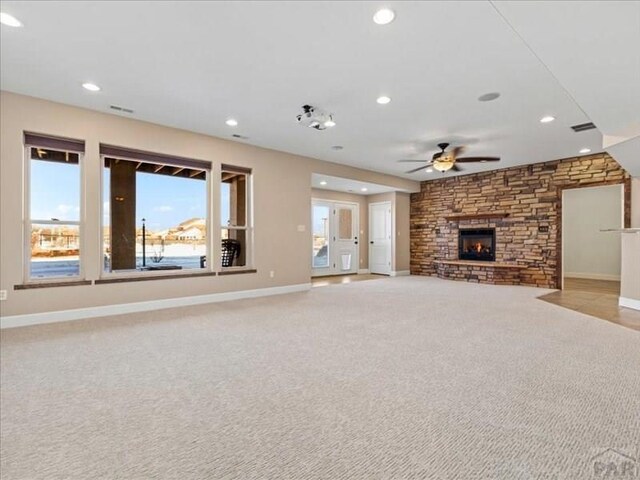 unfurnished living room with recessed lighting, light colored carpet, a fireplace, and baseboards