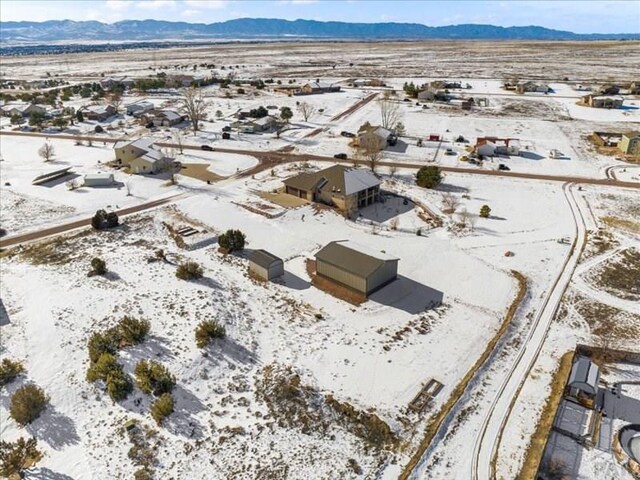 snowy aerial view with a mountain view